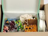 a cardboard box filled with assorted items on a white surface