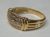 an image of a gold and diamond ring on a white surface