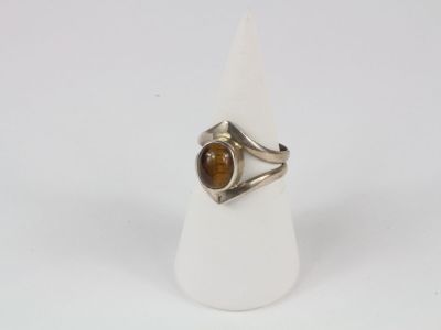 un gros plan d'une bague en argent sertie d'une pierre « œil-de-tigre »