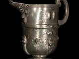 a silver vase with a handle on a black background