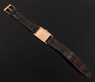 a close up of a watch on a black surface