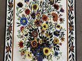 une photo d'un patchwork sur lequel figure un vase de fleurs