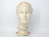 une statue représentant la tête d'une femme posée sur un socle