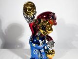 une figurine représentant une personne tenant un trophée