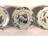 trois assiettes bleues et blanches ornées de fleurs, posées sur une table
