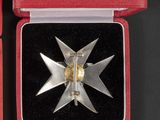 an image of a silver and gold medal in a red box
