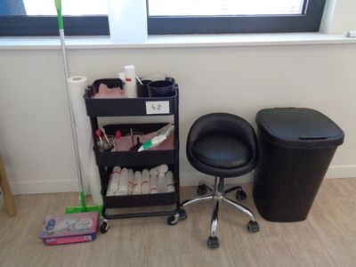 une chaise noire et une poubelle noire dans un coin de la pièce