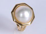 a close up of a ring with a pearl inside of it
