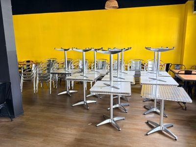 de nombreuses tables et chaises dans une pièce aux murs jaunes