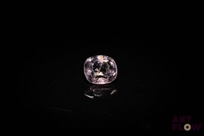 a close up of a pink diamond on a black surface