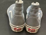 grey and white shoes with red logos on them sitting on a black surface