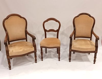 trois fauteuils rembourrés sont alignés contre un mur blanc