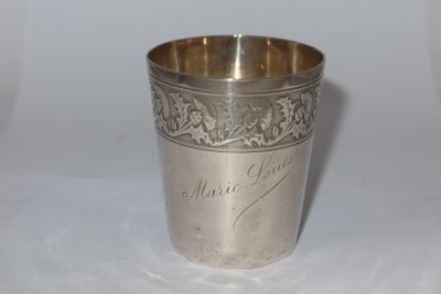 a silver cup sitting on a table with writing on it