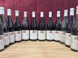 six bouteilles de vin sont alignées sur une table en bois