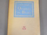 un vieux livre posé sur une table, à côté d'un livre à la couverture bleue et jaune