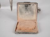 a small silver box with a ring inside of it