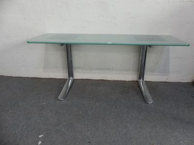 une table en verre avec des pieds en métal et un plateau en verre