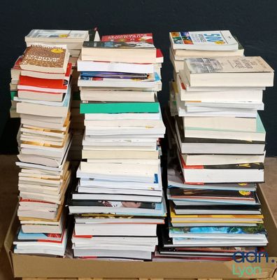 many books stacked on top of each other in a box