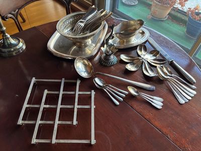 beaucoup d'argenterie sur une table, avec une fenêtre en arrière-plan