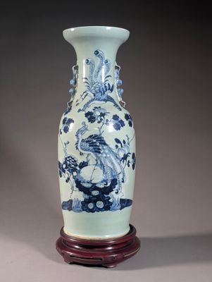 un vase bleu et blanc posé sur un support en bois