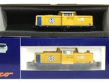 une boîte sur laquelle est représenté un train jaune et une boîte bleue sur laquelle est représenté un train blanc