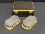 une paire de brosses argentées et une boîte posées sur une table
