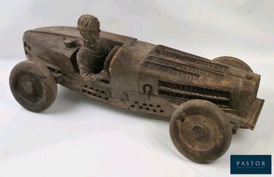 une petite voiture en bois avec un petit bonhomme à l'intérieur