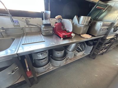 un mixeur rouge posé sur une étagère en métal dans une cuisine