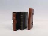 trois livres sont empilés sur une surface blanche