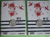 two packs of silver coins with red roses on them on a green surface