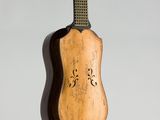 une vieille guitare accrochée au mur d'une pièce