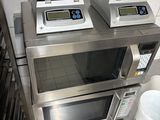 two microwaves sitting on top of each other on a counter