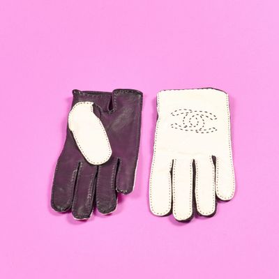 une paire de gants en cuir noir et blanc sur fond rose