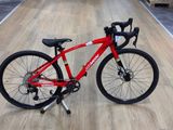 un vélo rouge posé sur un plancher en bois