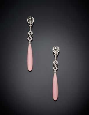 une paire de boucles d'oreilles roses et argentées sur fond noir