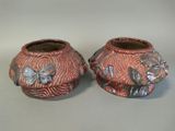 pair of small vases with butterflies on them sitting on a table