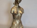 une statue de femme assise sur une table