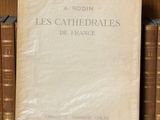 un vieux livre posé sur une étagère en bois, à côté d'une pile de livres