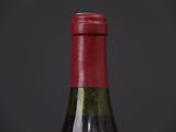 bottle of red wine on a black table with a dark background