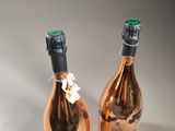 two bottles of champagne sitting next to each other on a table