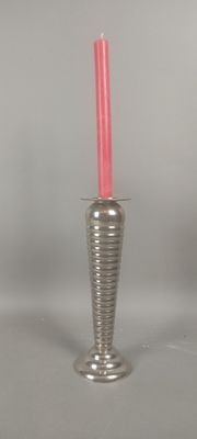 un vase en argent contenant une bougie rose