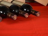 several bottles of wine are lined up on a red table cloth