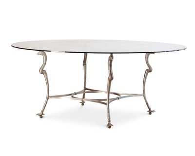 une table à manger ovale avec un plateau en verre et des pieds en métal