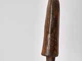 statue of a man in a hat and coat standing on a wooden base
