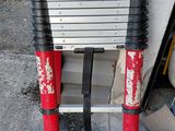 une échelle rouge et noire appuyée contre un mur