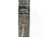 a black vase with a design on it on a white surface