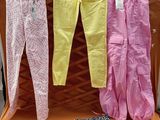 trois paires de pantalons roses et jaunes suspendues à un portant