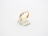 une bague en or posée sur un bloc de marbre blanc