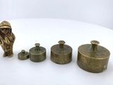 three brass figurines of a man and a dog on a white surface
