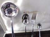 a silverware set in a box with a spoon, fork and spoon rest